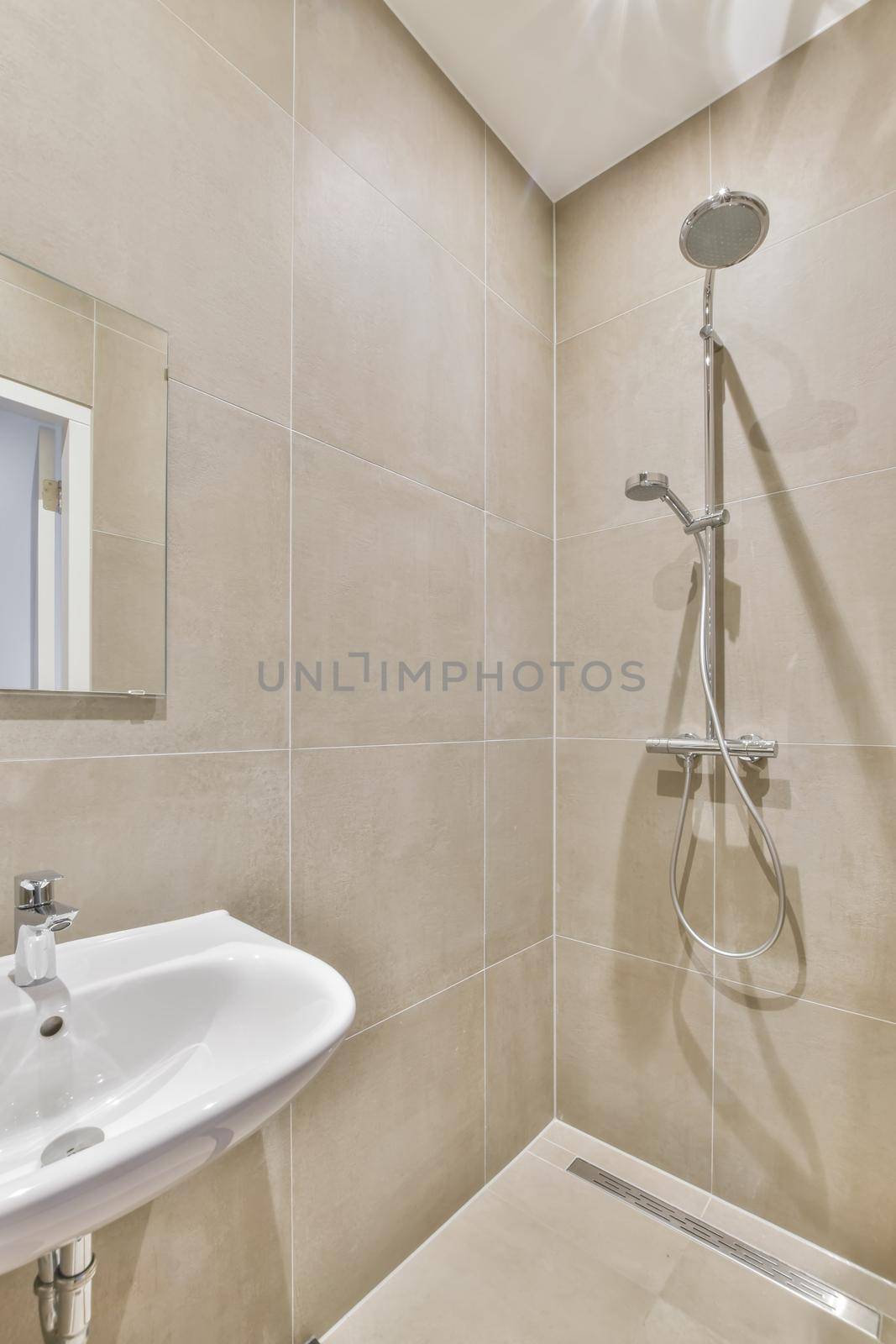 The interior of the bathroom is covered with beige tiles by casamedia