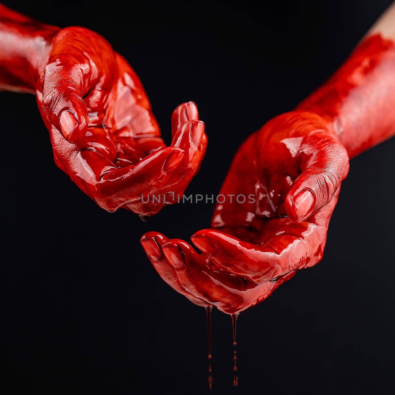 Women's hands in blood on a black background