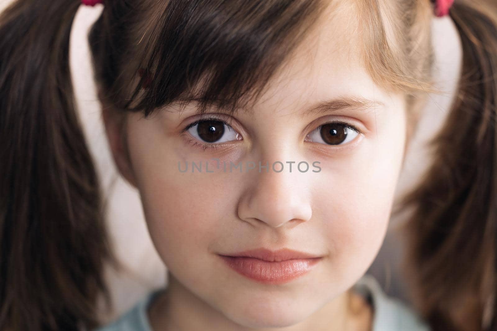 Close-up face portrait of a beautiful little girl. Caucasian little girl looking at the camera. Happy childhood concept