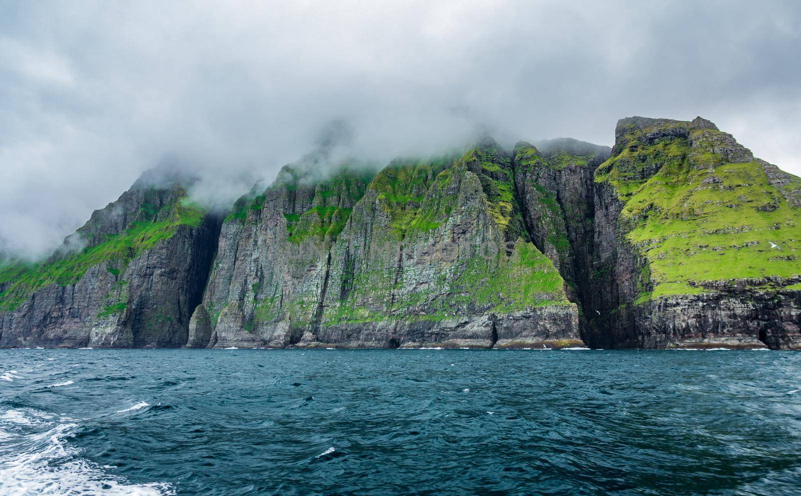Bottom view of the spectacular Vestmanna cliffs under the mist in the Faroe Islands
