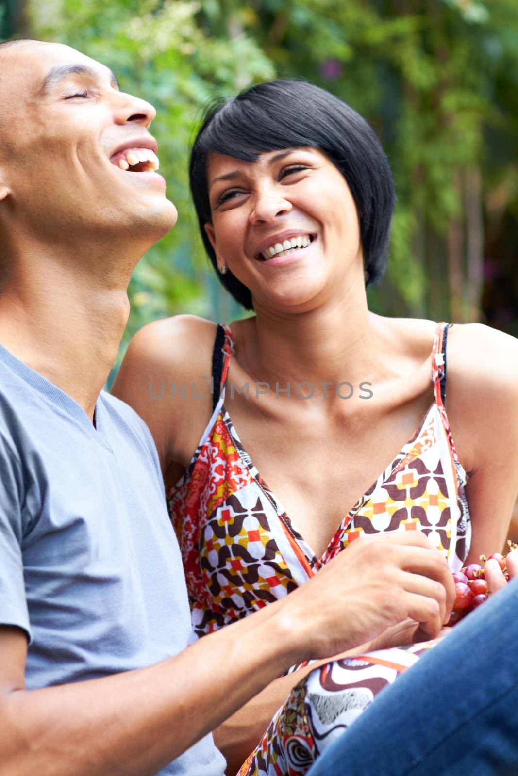 Love and laughter in the outdoors. Shot of a young couple enjoying the outdoors together. by YuriArcurs