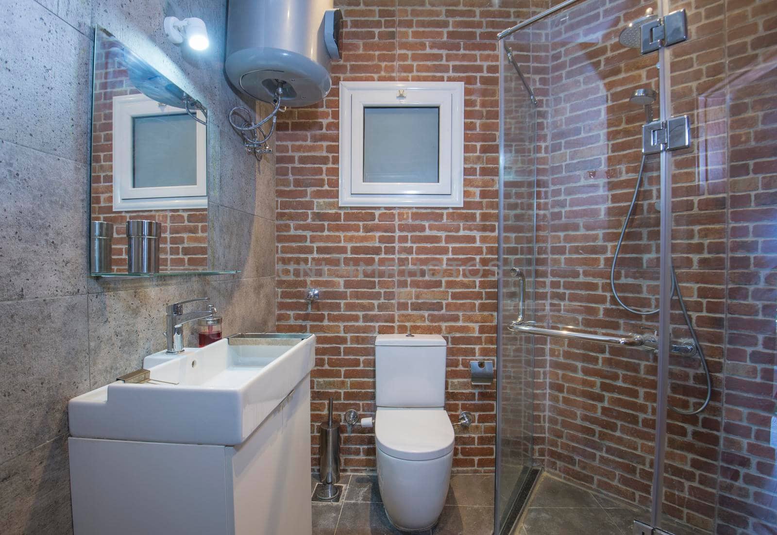 Interior design of a luxury show home bathroom with brick wall effect shower cubicle and sink