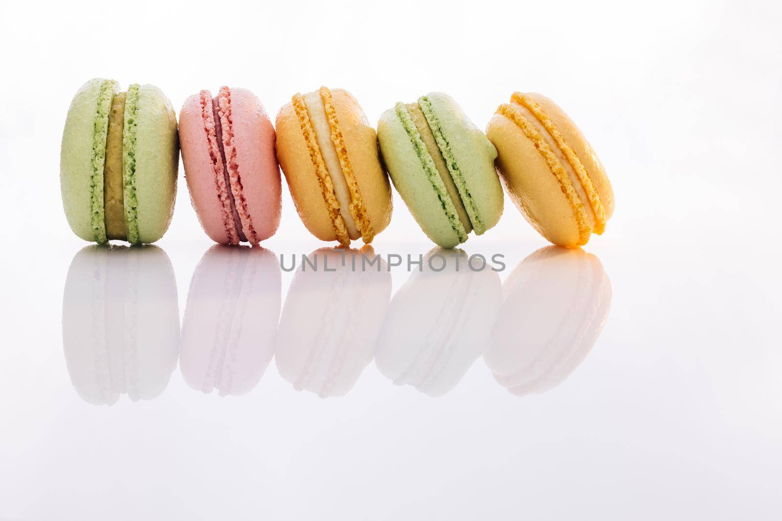 Different colorful macaroon. Tasty sweet color macaron. Colorful macarons dessert. French macarons on white background.