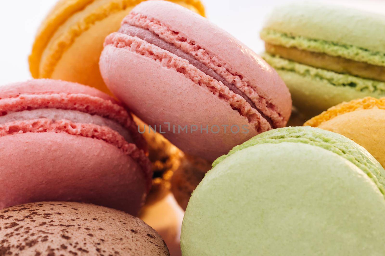 Macarons dessert. Close up of multicolor macarons French macaroon greedy pastry on white background. Food concept by uflypro