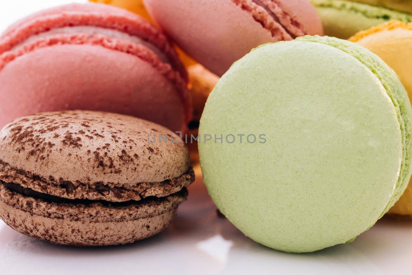 Close up of multicolor macarons French macaroon greedy pastry on white background. Macarons dessert. Food concept.