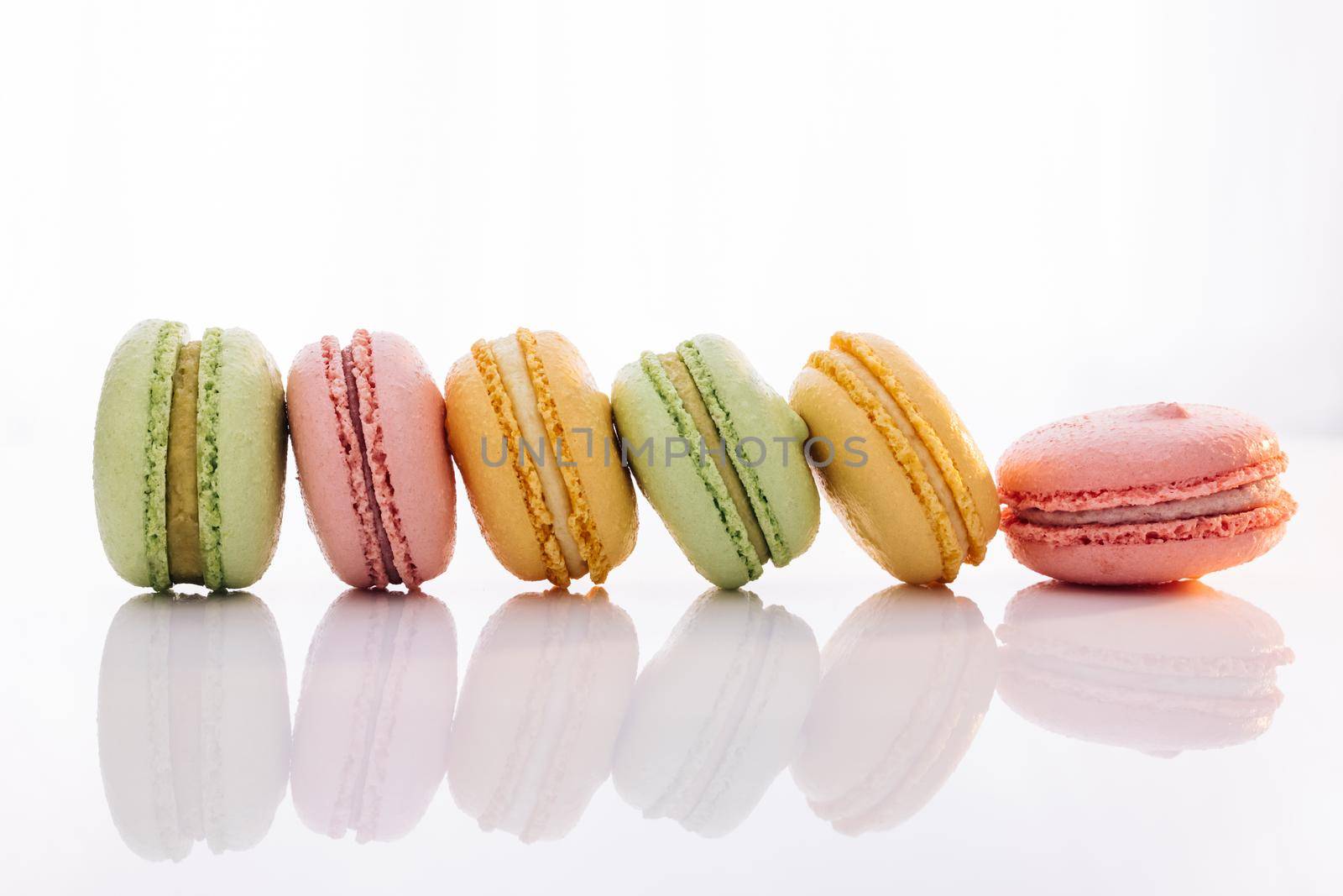 French macarons on white background. Different colorful macaroon. Tasty sweet color macaron. Colorful macarons dessert.