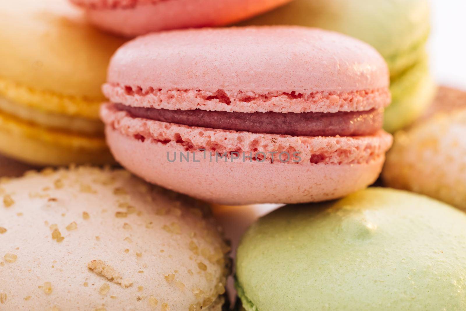 Macarons dessert. Close up of multicolor macarons French macaroon greedy pastry on white background.Food concept by uflypro