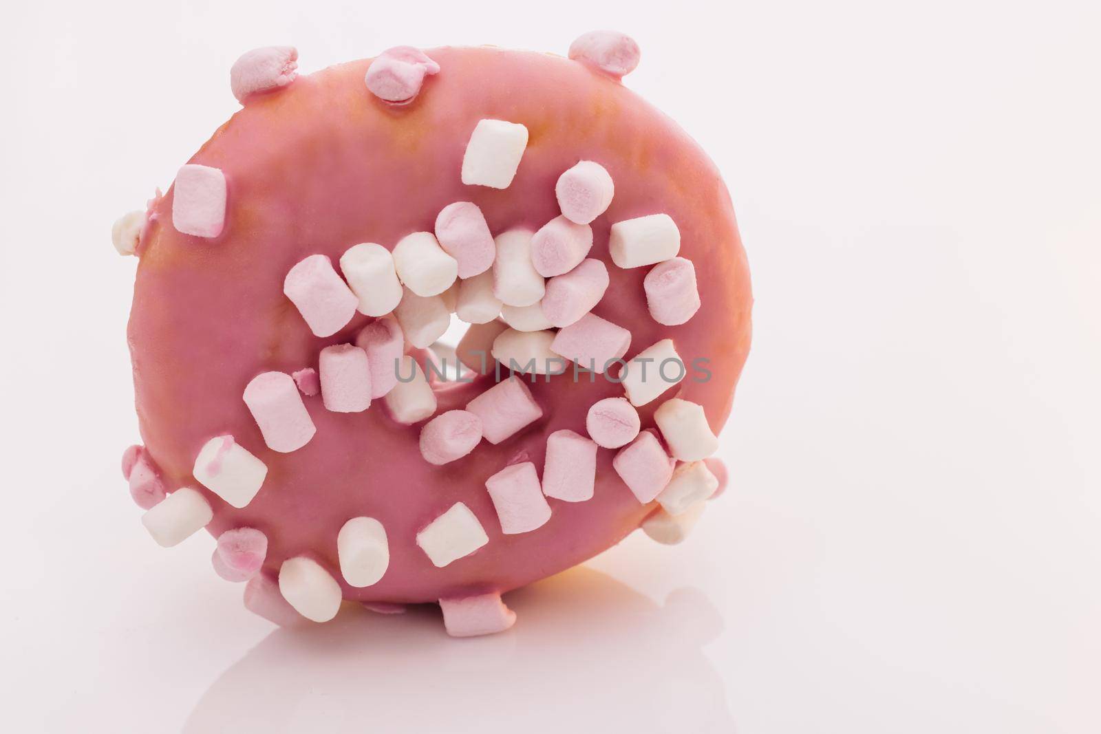 Pink glazed marshmallow donut. Bright and colorful sprinkled donut on a white background. Assortment of donuts of different flavors by uflypro