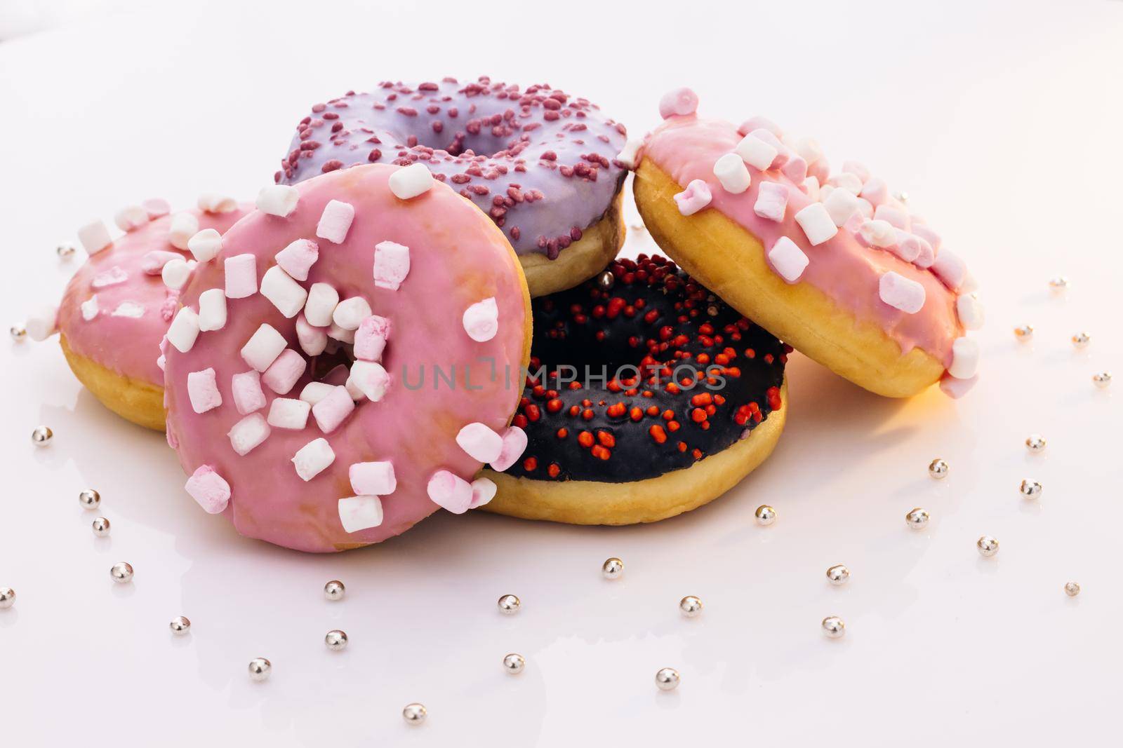 Donuts of white background. concept art. Donuts of different colors. Glazed sweet desserts. Fast food, Bakery concept. Various colorful donuts. Chocolate, purple, pink donuts