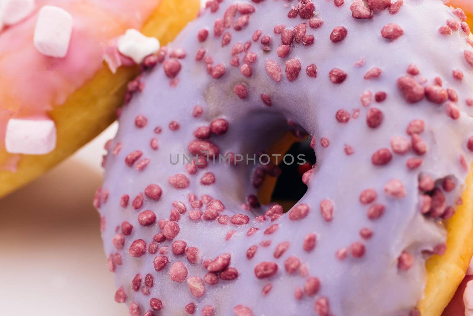 Close-up shot of tasty delicious sweet buns donuts with colorful icing and sprinkles. Dessert, bakery and confectionery. Tasty donuts. Assortment of donuts of different flavors