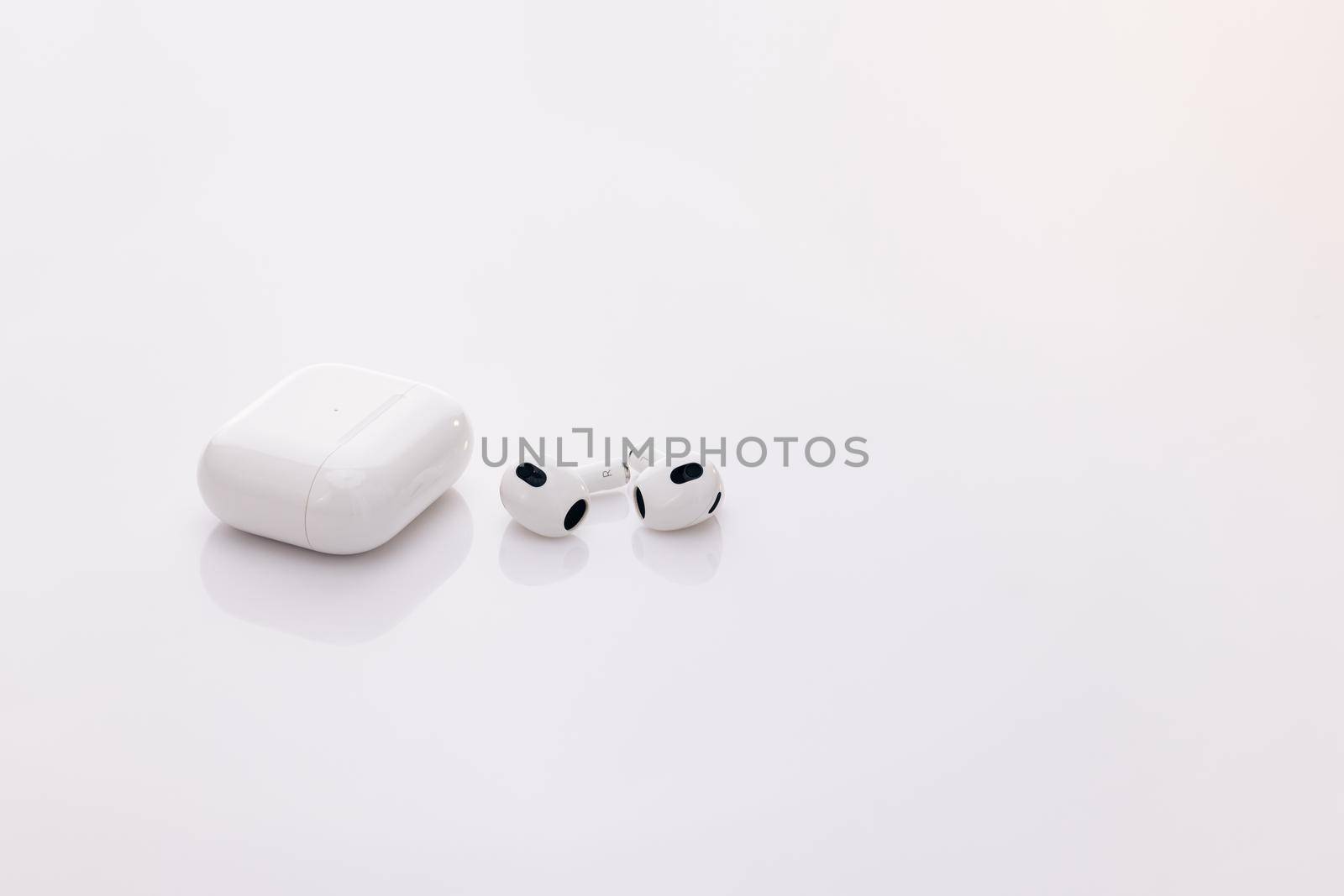 Gadgets and electronic devices. Wireless headphones with charging case. Wireless earphone with noise cancelling technology. Bluetooth headphones isolated on white background.