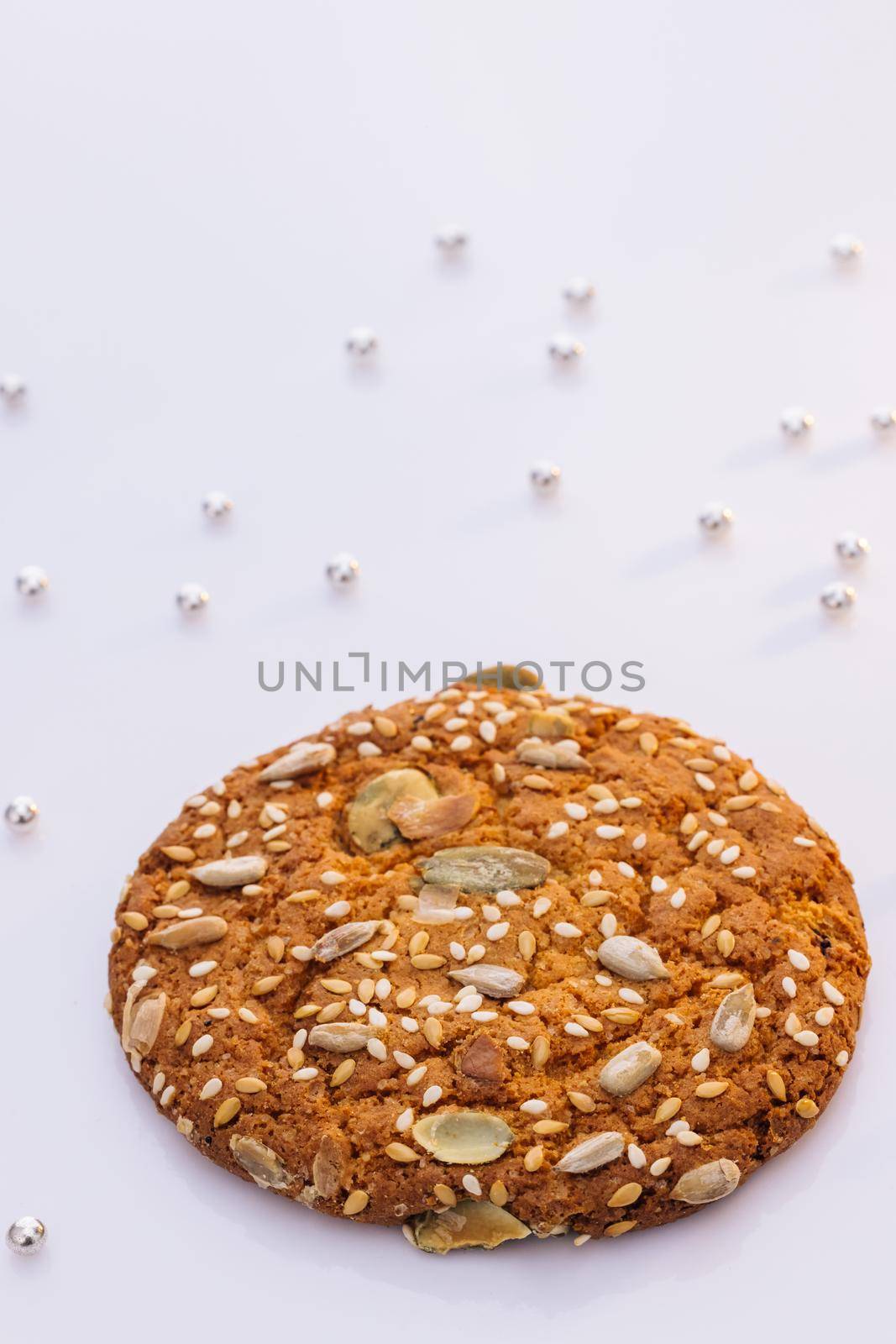 Eat oatmeal cookies. The concept of making chip cookies. Delicious tasty snack of brown cookies isolated on white background. Wheat fall on dietary cookies by uflypro