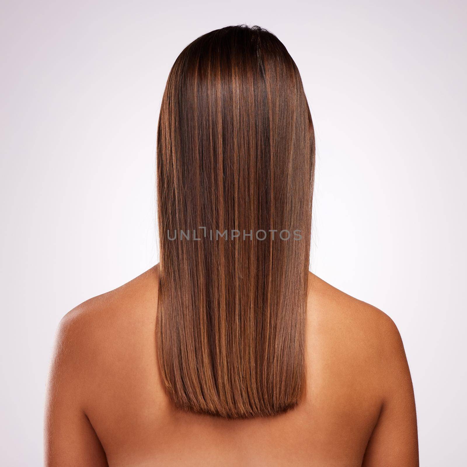 Perfectly layered. Studio shot of an unrecognizable young woman standing with her back facing the camera to show off her hair against a grey background. by YuriArcurs