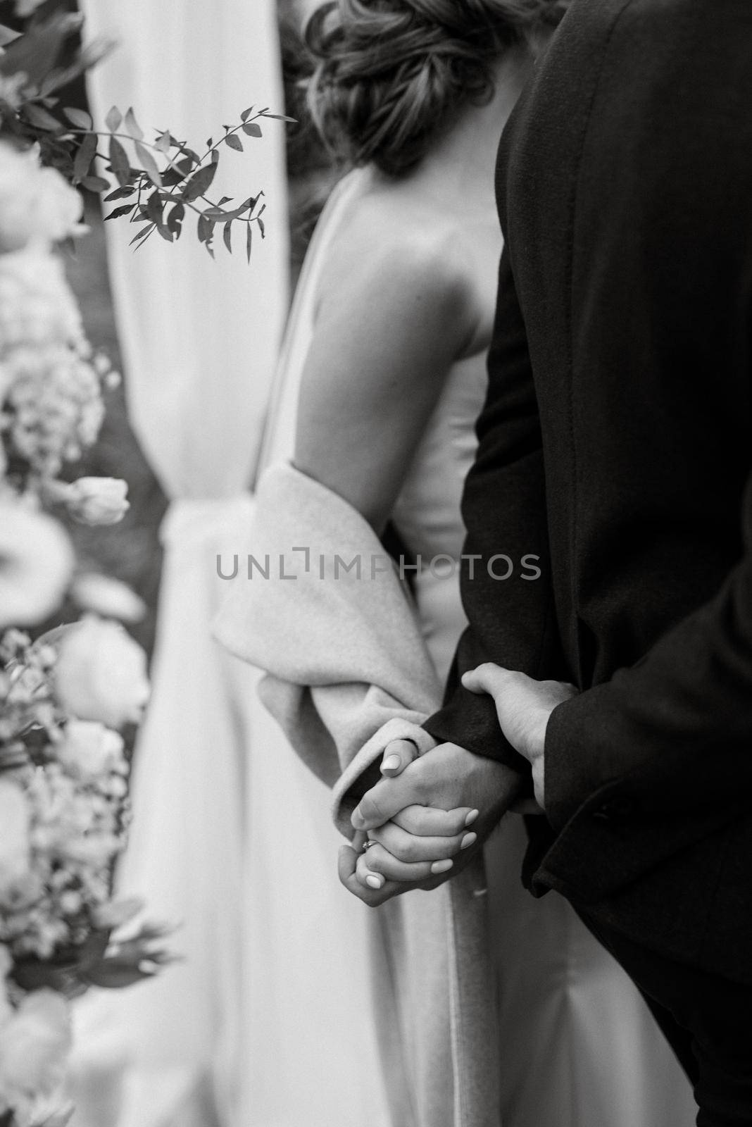 the bride and groom tenderly hold hands between them love and relationships