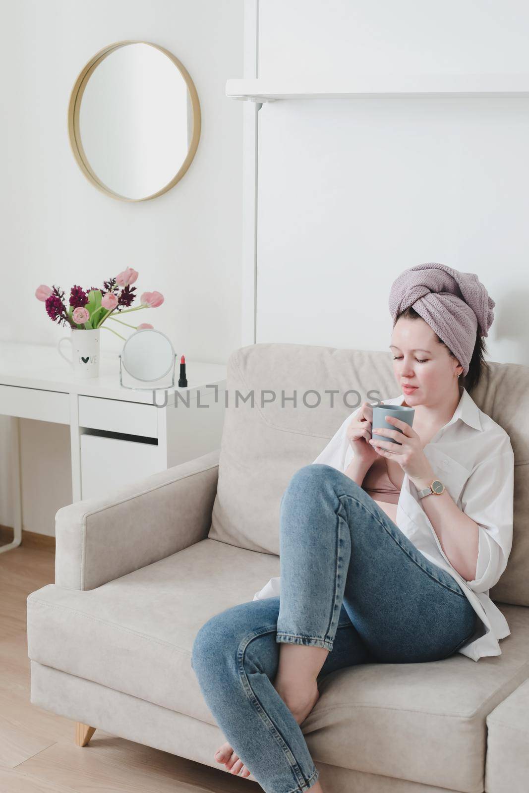 Good morning, smiling young woman drinking coffee in a cozy room at home