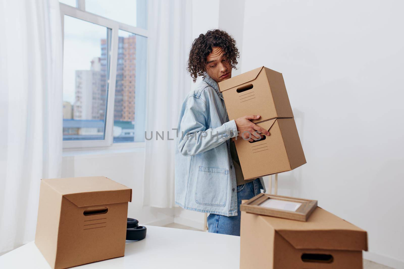 portrait of a man unpacking things from boxes in the room Lifestyle. High quality photo
