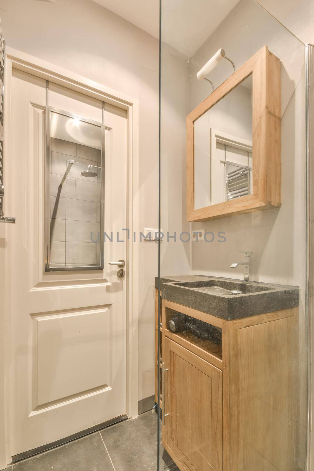 The interior of the bathroom in gray tones with a marble sink and a glass shower cabin