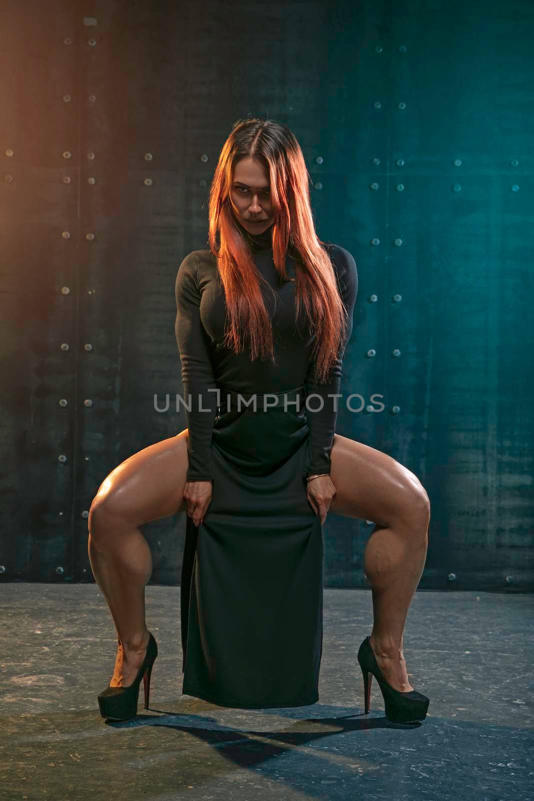 Attractive redhead girl in black plunging dress demonstrates athletic legs with big calves