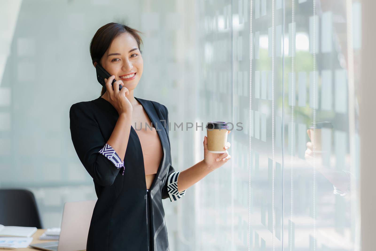 Business woman talking with customer by cell phone at office