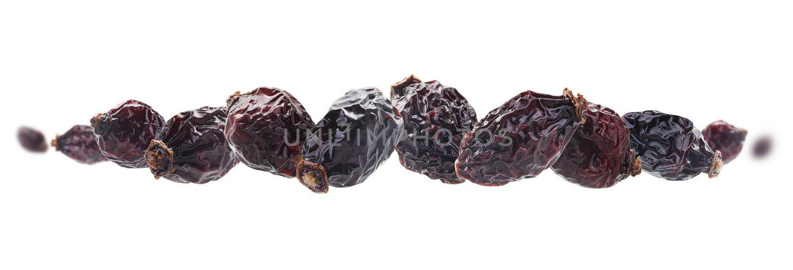 Dried rosehip berries levitate on a white background.