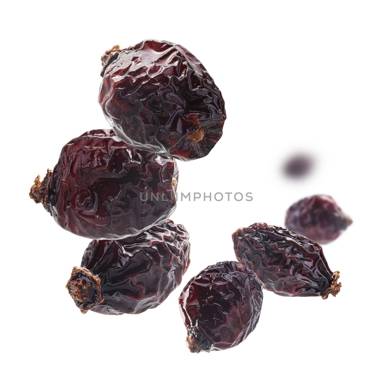 Dried rosehip berries levitate on a white background.
