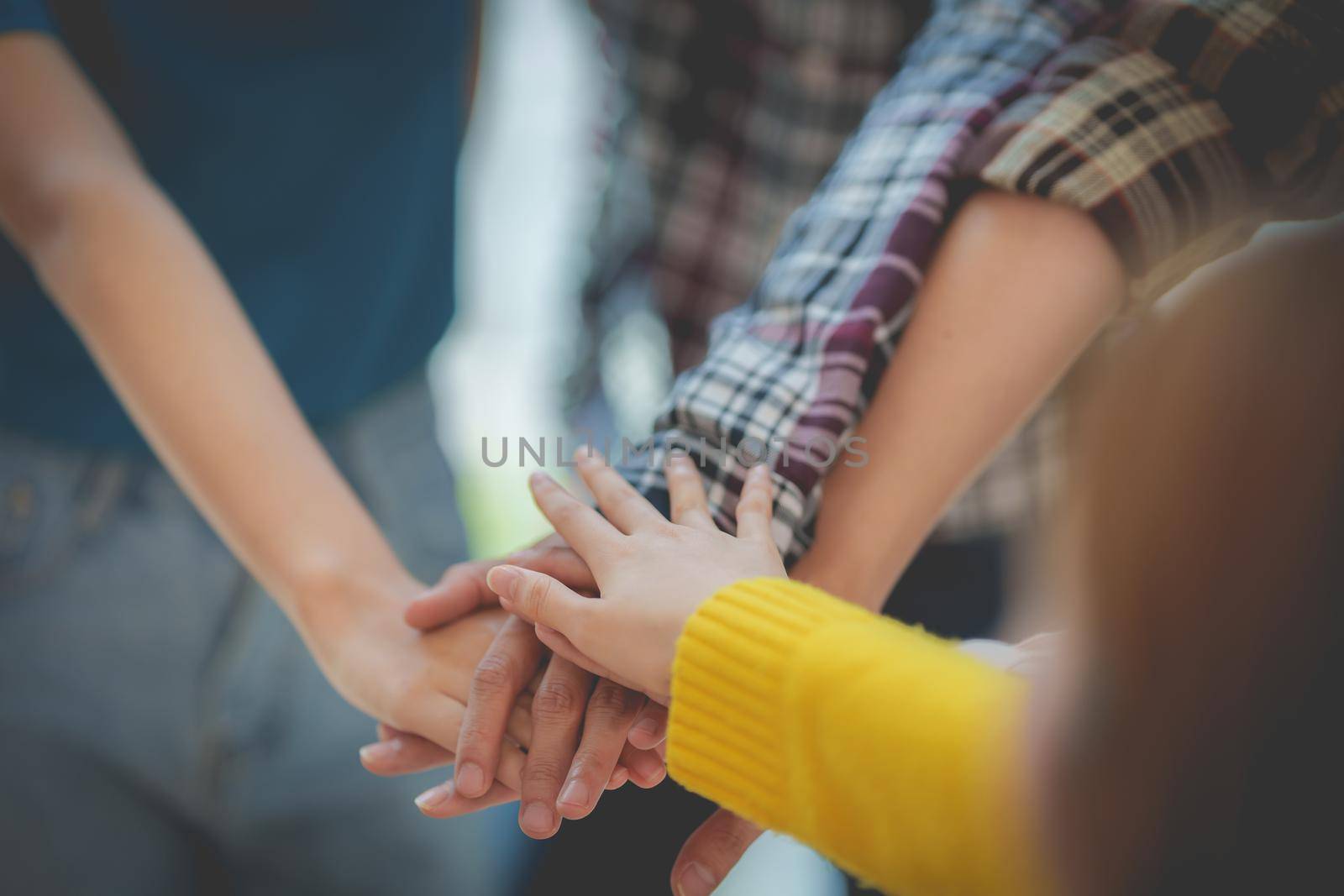 Group of business people putting their hands working together on wooden background in office. group support teamwork agreement concept