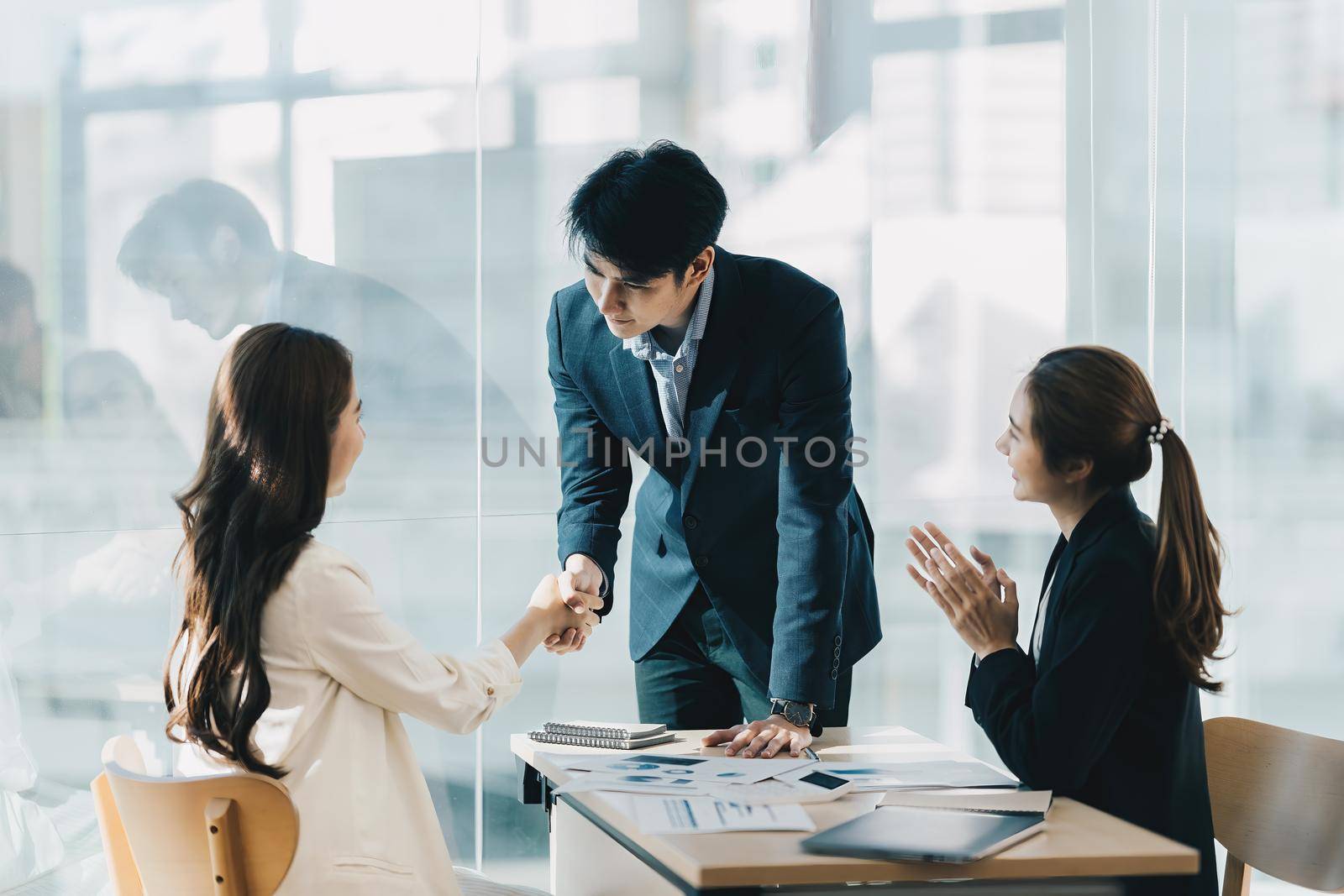 Business partnership meeting concept. Image business women handshake. Successful business people handshaking after good deal. Group support concept. by itchaznong