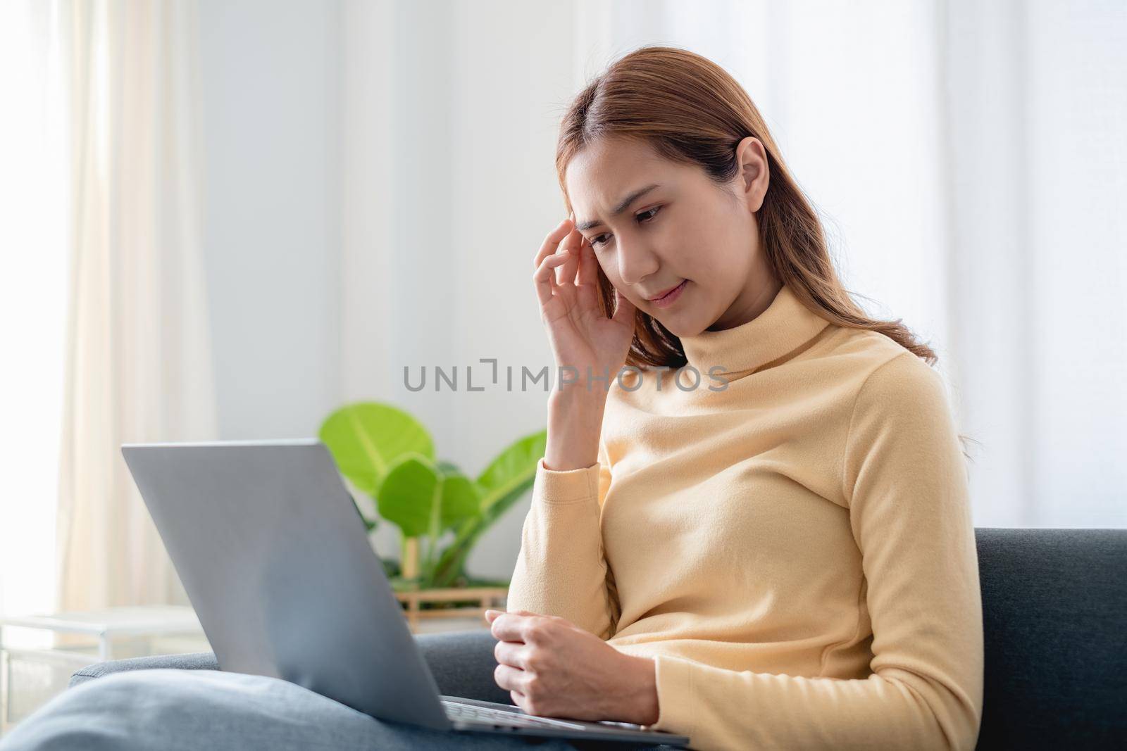 Frustrated stressed business woman sitting on sofa at home