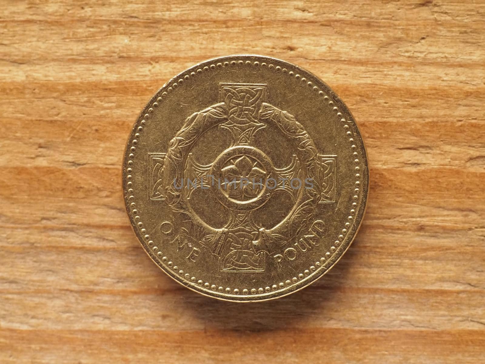 1 Pound coin, reverse side showing Celtic cross with pimpernel flower and torc representing Northern Ireland, currency of the UK by claudiodivizia