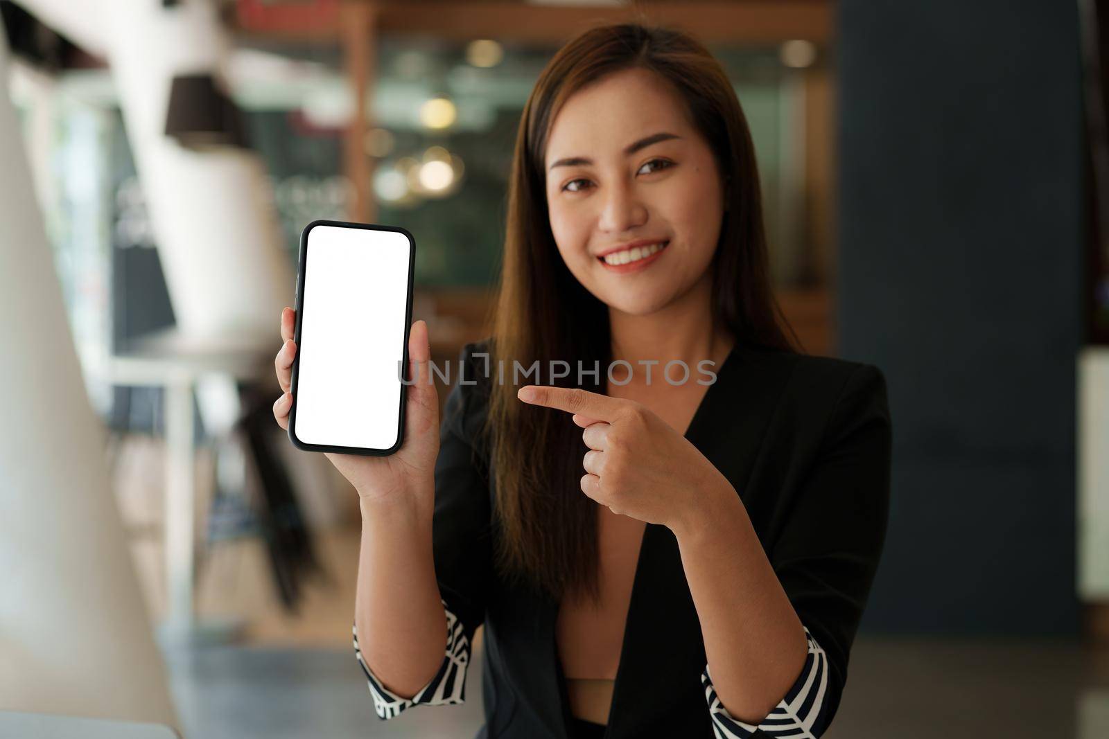 Woman showing smartphone with blank screen for advertise