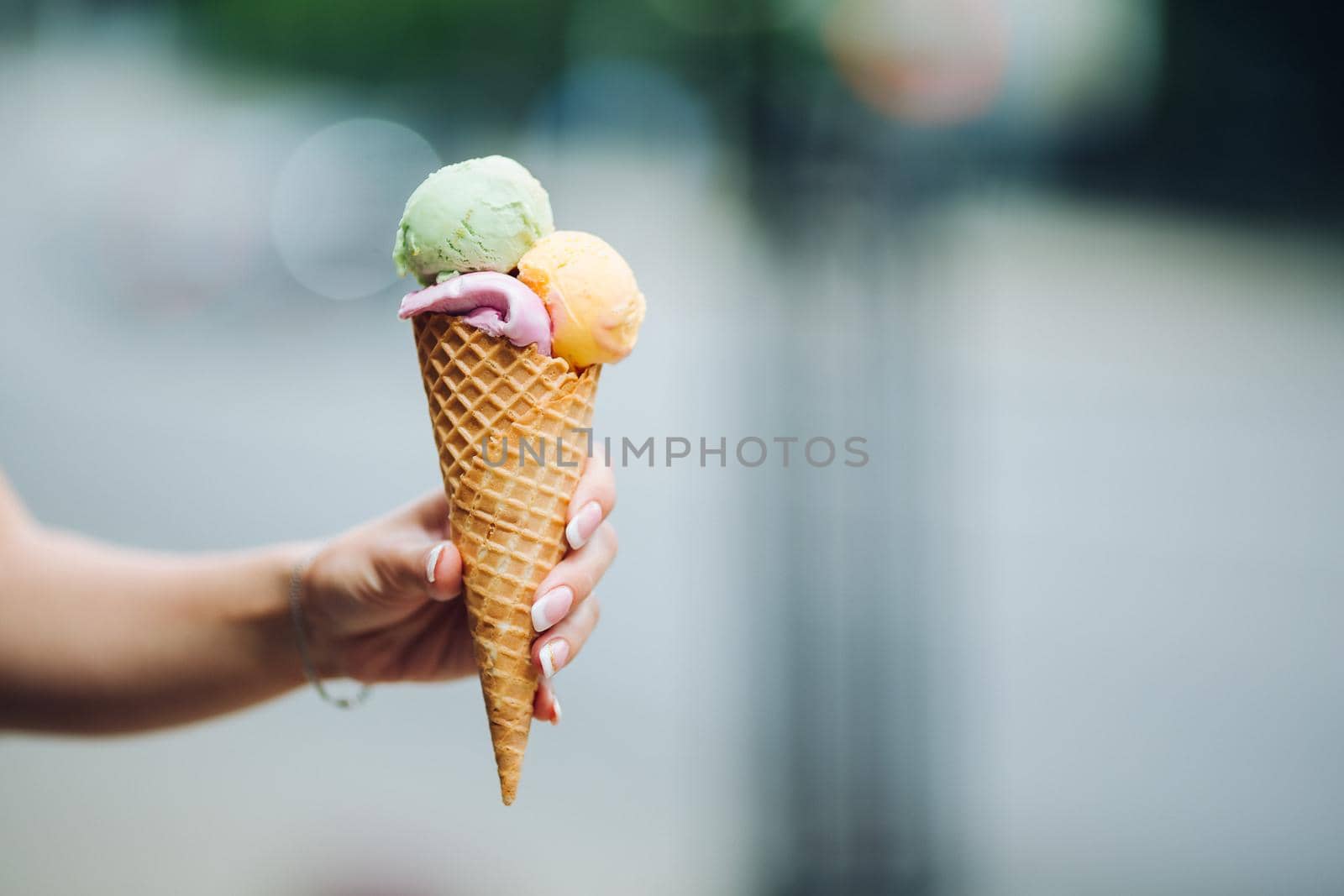 Woman holding delicious colorful ice cream.Summertime vibes and sweet food. by StudioLucky