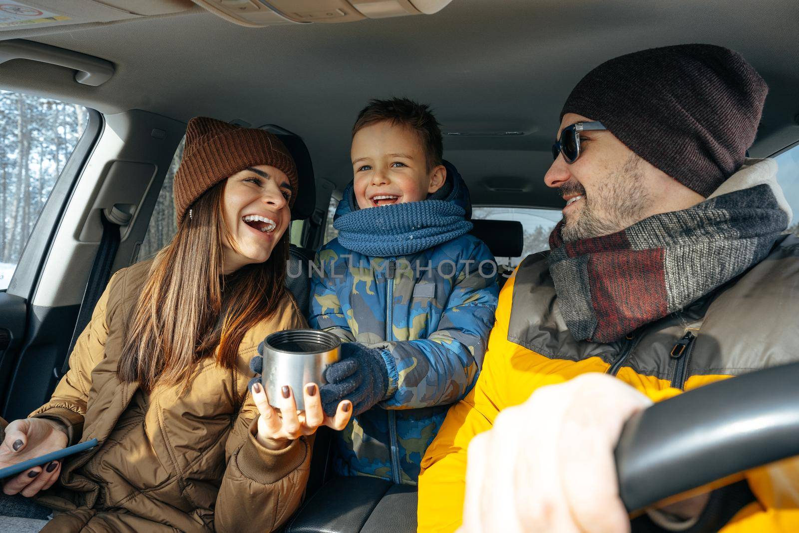 Mother, father and child traveling by car on a vacation to the mountains in winter, close up