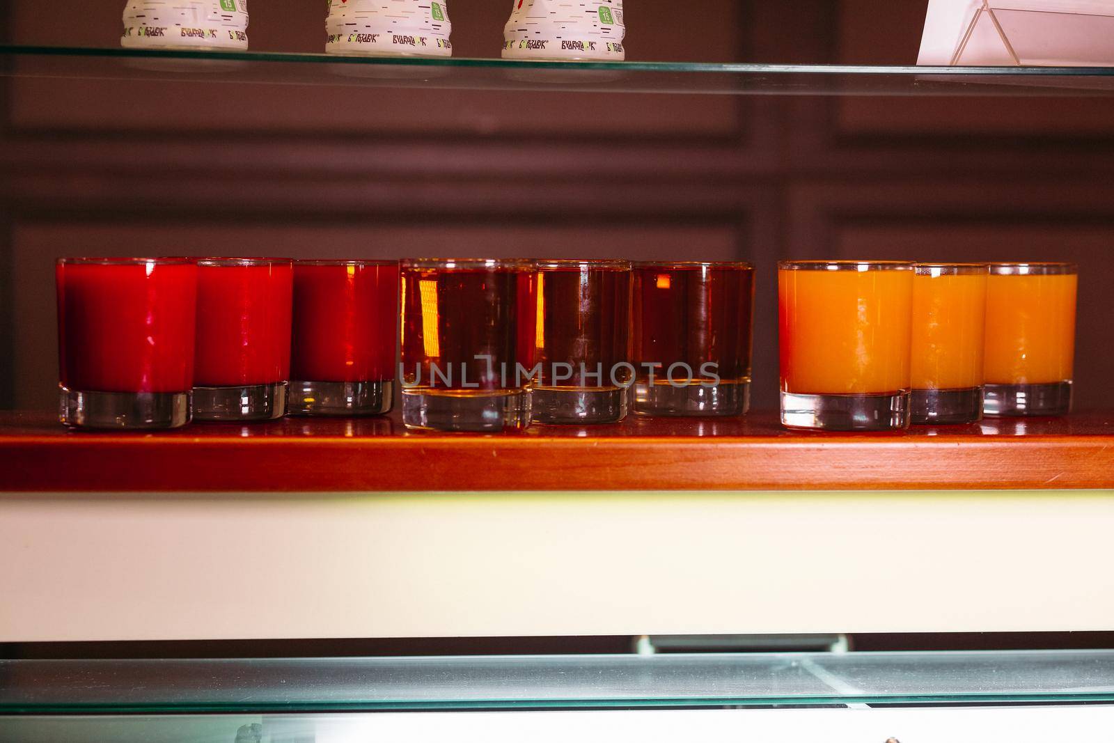 View of set of different juice and cocktails on self in bar. Fresh drinks with and without alcohol. Restaurant drinks. Concept of food.
