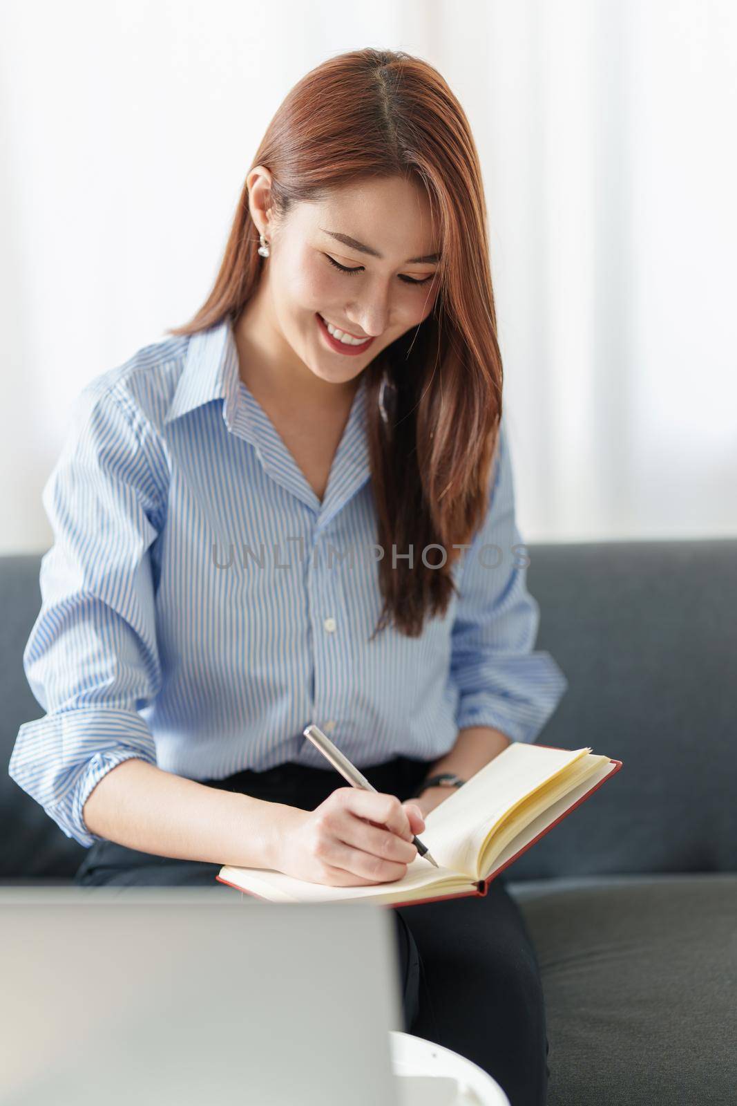 Beautiful Asian Business woman watching educational webinar on laptop computer. Finance concept. by itchaznong