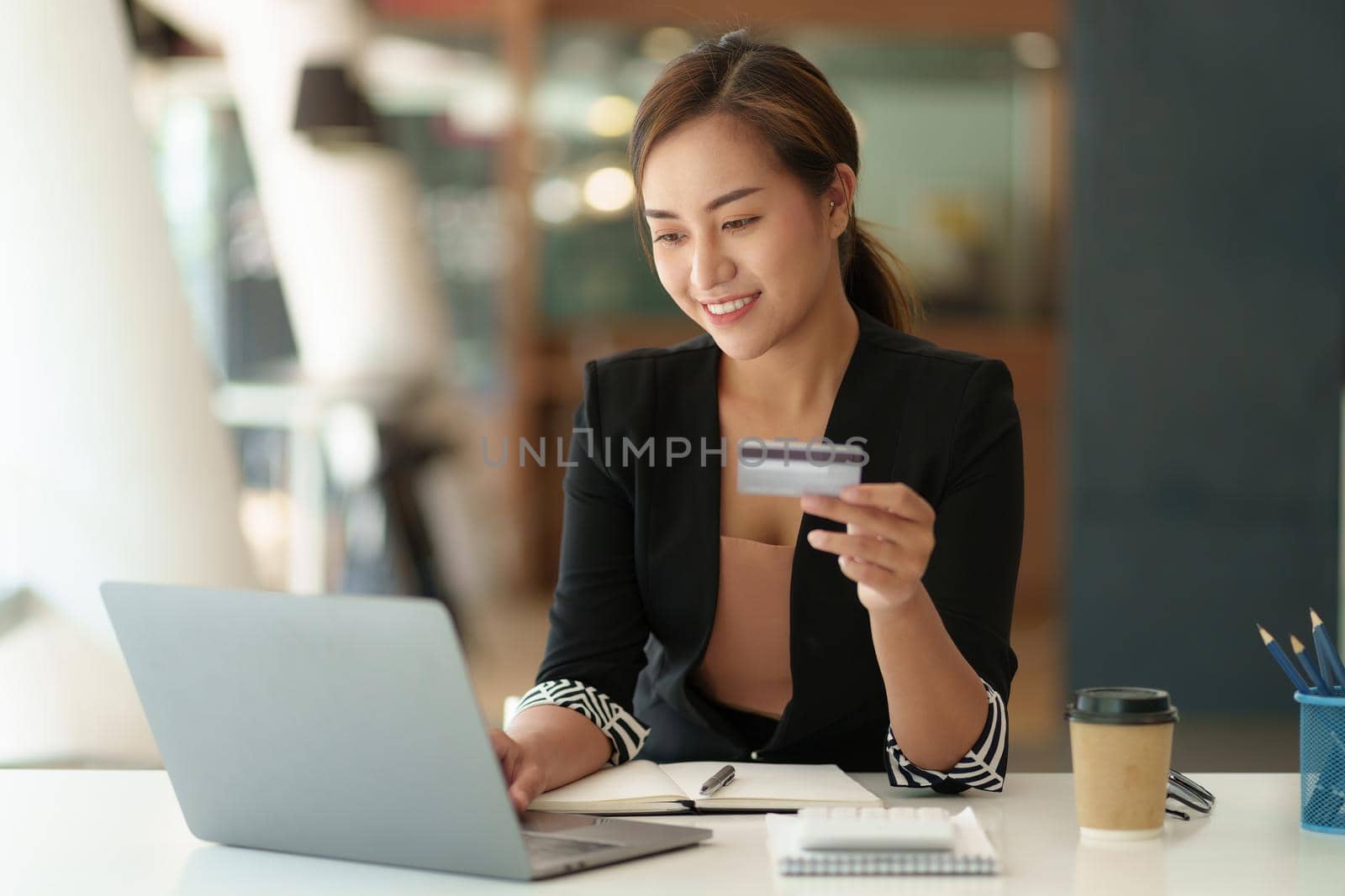 Woman using shopping web site by laptop computer and payment by credit card