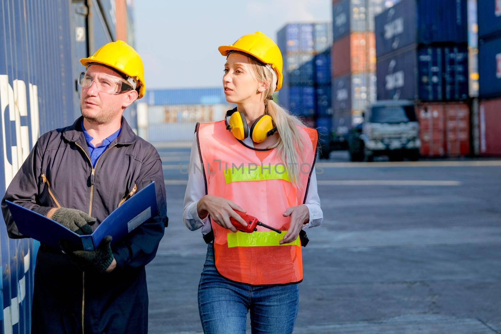 Technician or workers man and woman discuss about the product in cargo container shipping area with day light. by nrradmin