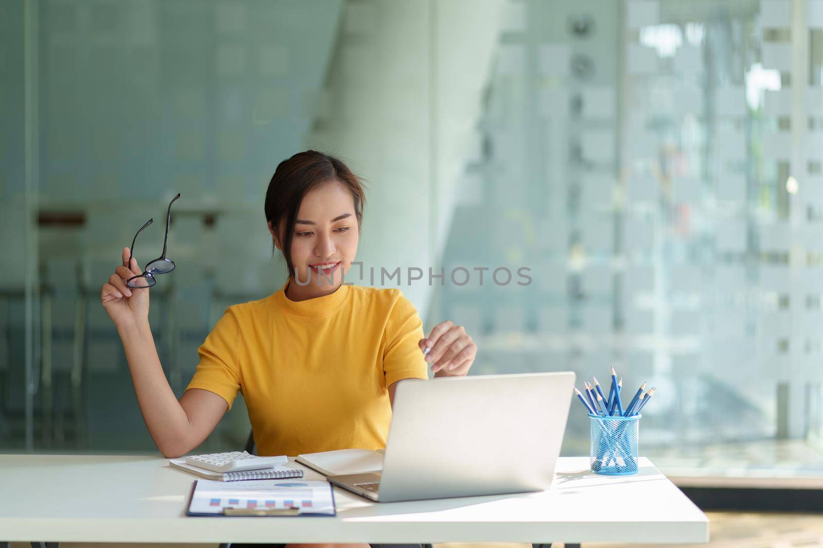 Business woman hand holding pen looking at bank savings account application on laptop. account or saving money or insurance concept