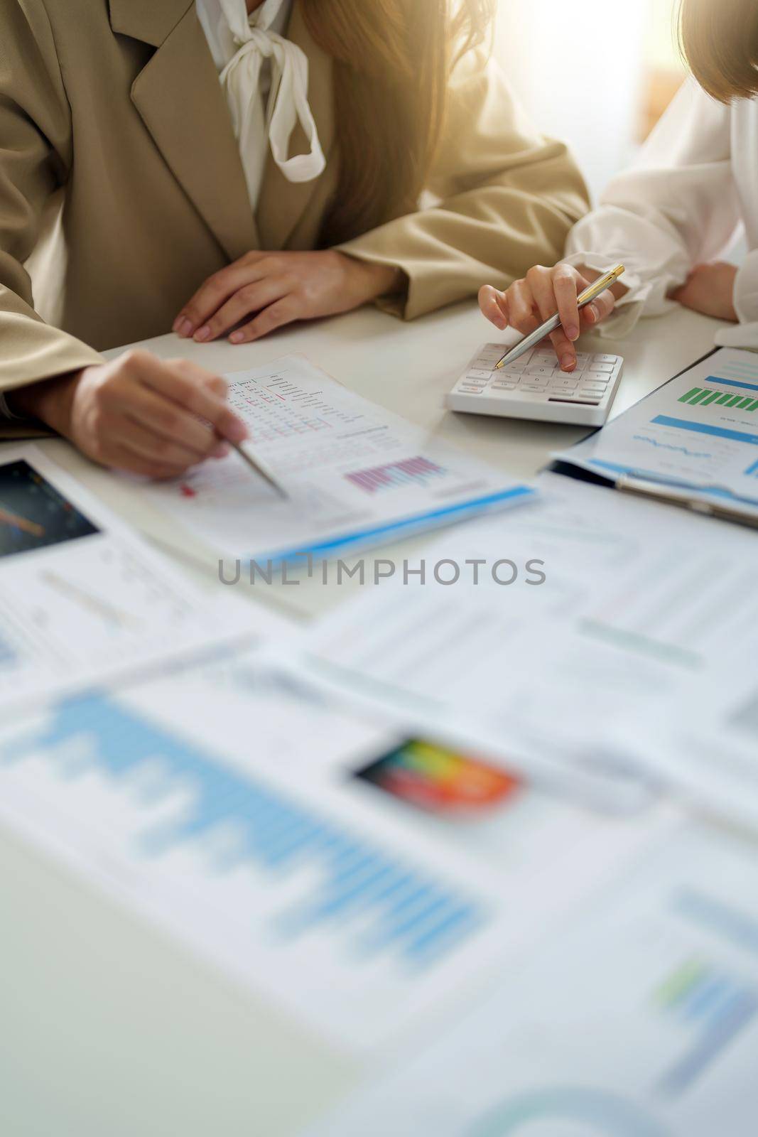 Crop image of business partnership coworkers using a calculator analysis graph company financial budget report and cost work progress and planning on workplace. by nateemee