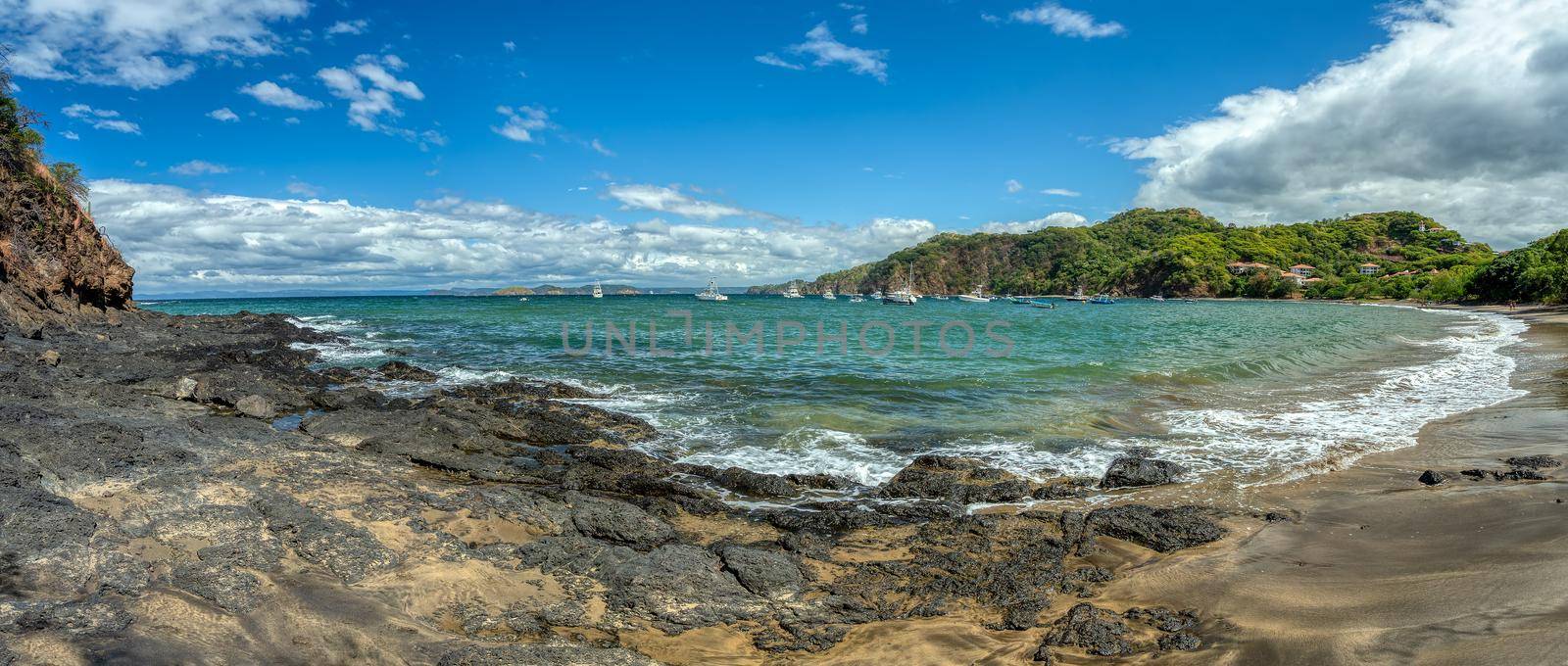 Playa Ocotal with Pacific ocean waves on rocky shore, El Coco Costa Rica. Famous snorkel beach. Picturesque paradise tropical landscape. Pura Vida concept, travel to exotic tropical country.