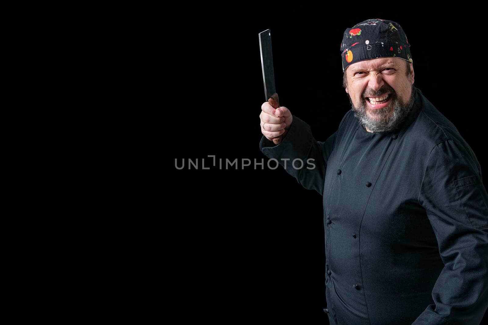 Portrait of angry chef with knife in hand with black background and copy space on the left side. Concept expressions.