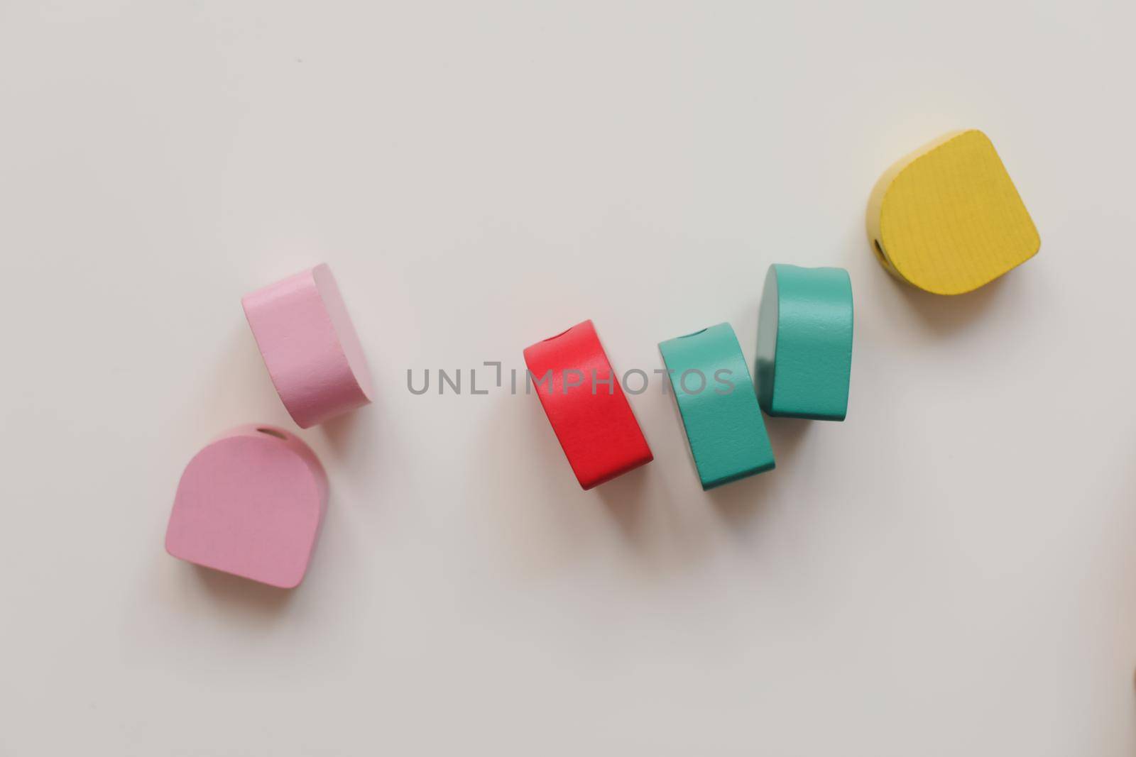 Top view colorful eco-friendly non-plastic wooden toys on white table. Early learning and development.