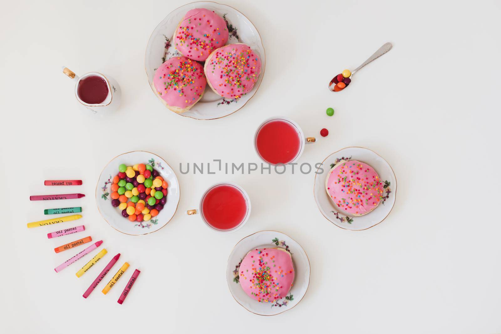 holiday, birthday party composition with colorful pink glazed donuts on white table, flatlay top view. 