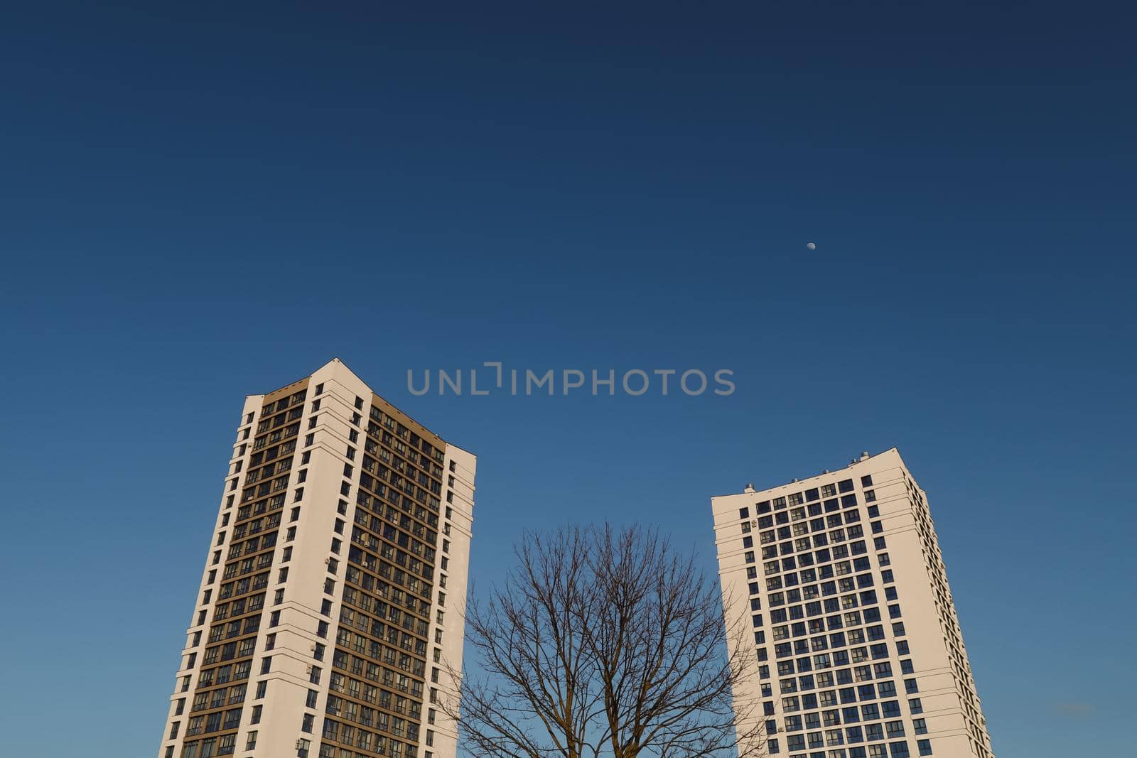 The urban landscape of large city. Exteriors of typical modern apartment buildings against a blue sky with clouds