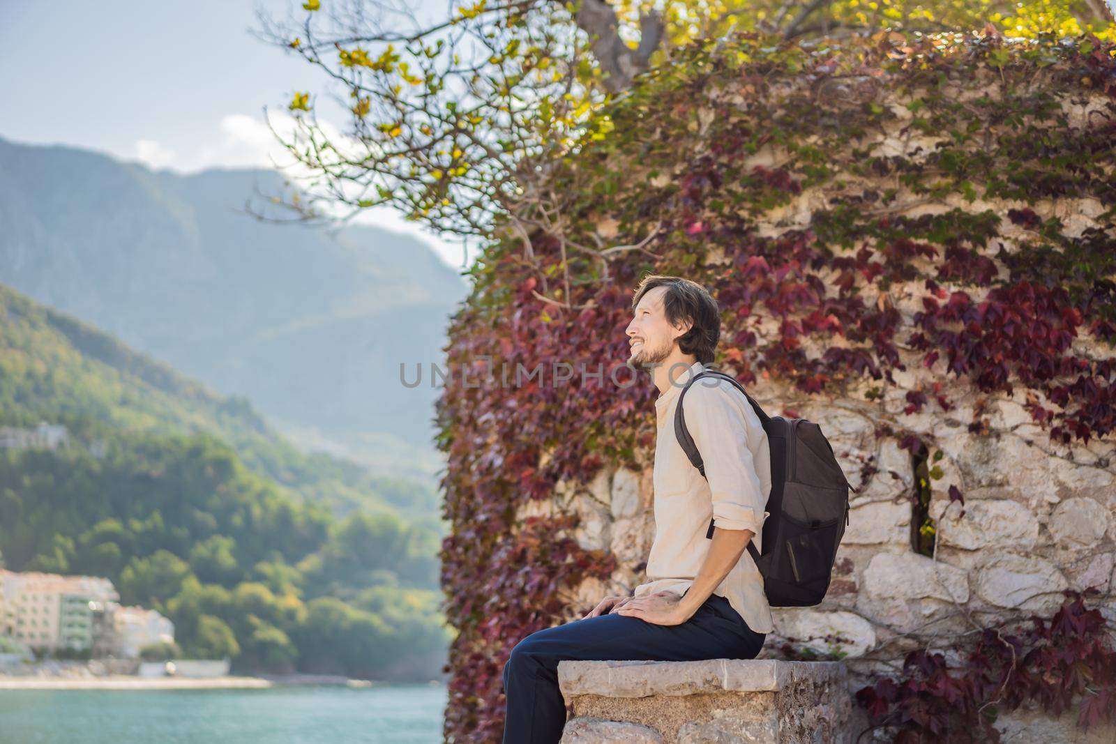 Man tourist on background of beautiful view of the island of St. Stephen, Sveti Stefan on the Budva Riviera, Budva, Montenegro. Travel to Montenegro concept by galitskaya