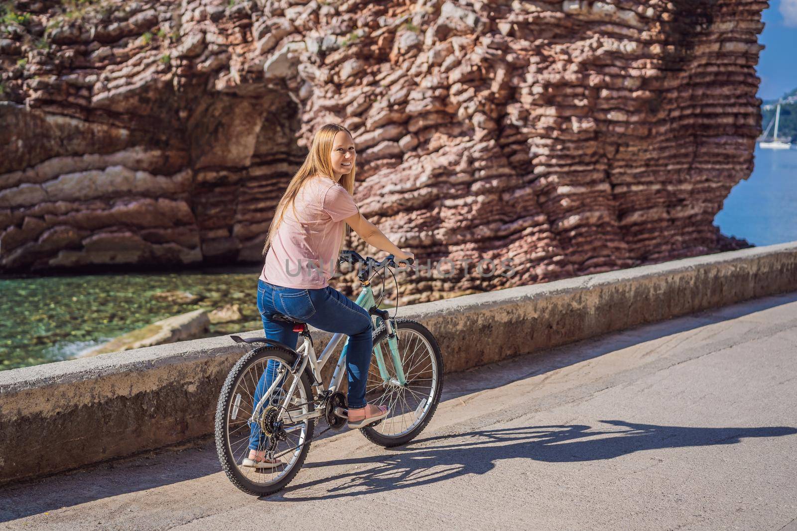 Woman tourist on a bicycle explores Budva in Montenegro. Cycling in Montenegro concept by galitskaya