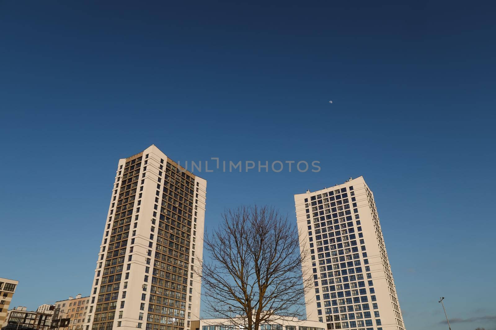 The urban landscape of large city. Exteriors of typical modern apartment buildings against a blue sky with clouds