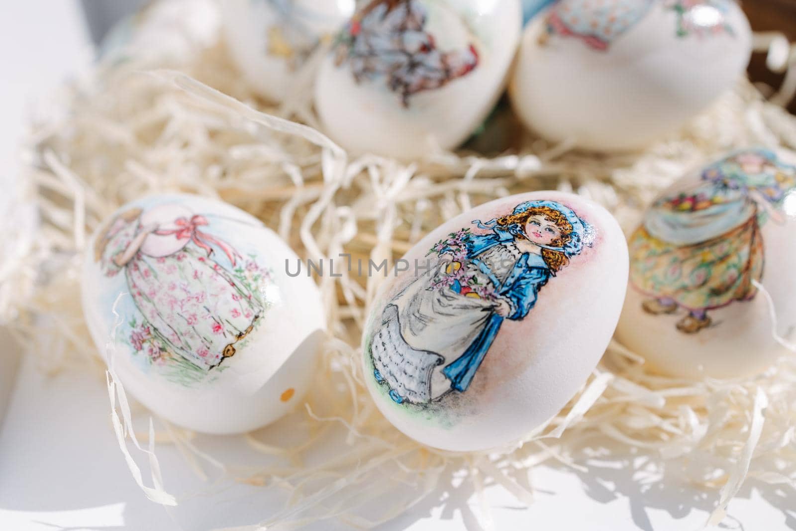 Close-up of different drawings on goose eggs for Easter festival. Eggs on hay. Hand made print. Spring hollidays. Easter concept.
