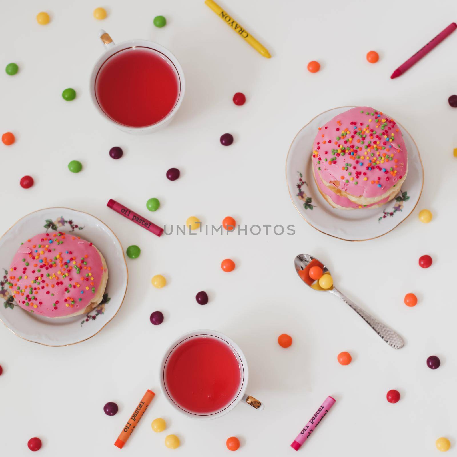 holiday, birthday party composition with colorful pink glazed donuts on white table, flatlay top view. 
