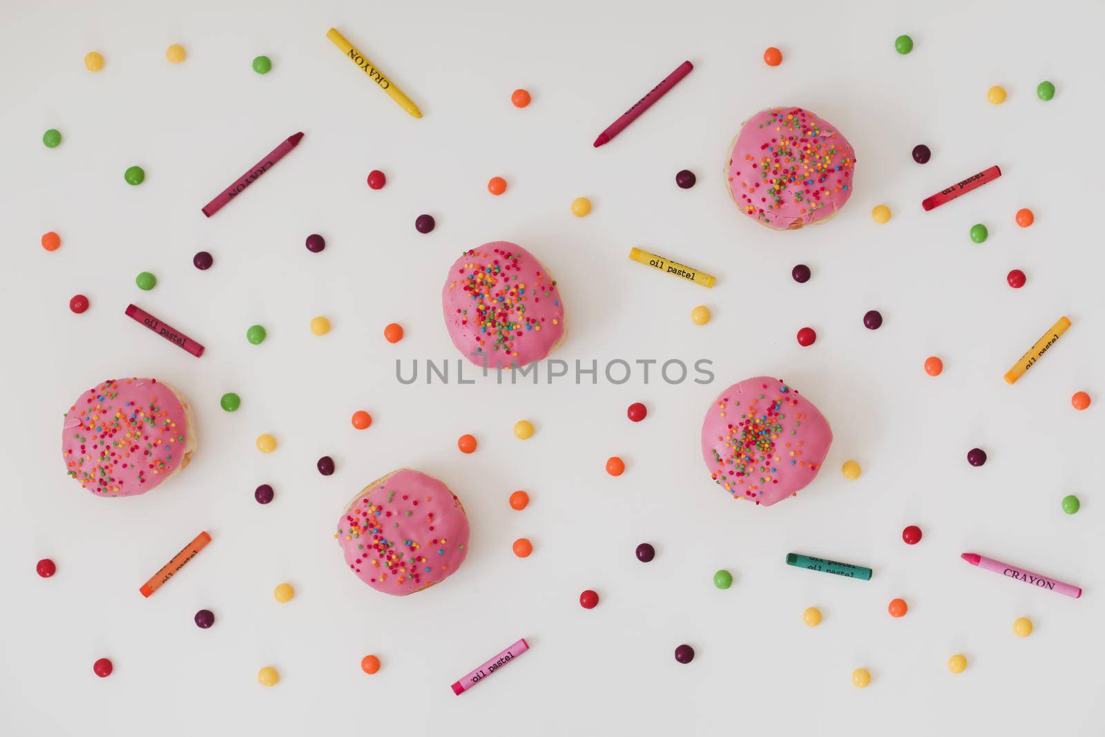 holiday, birthday party composition with colorful pink glazed donuts on white. 