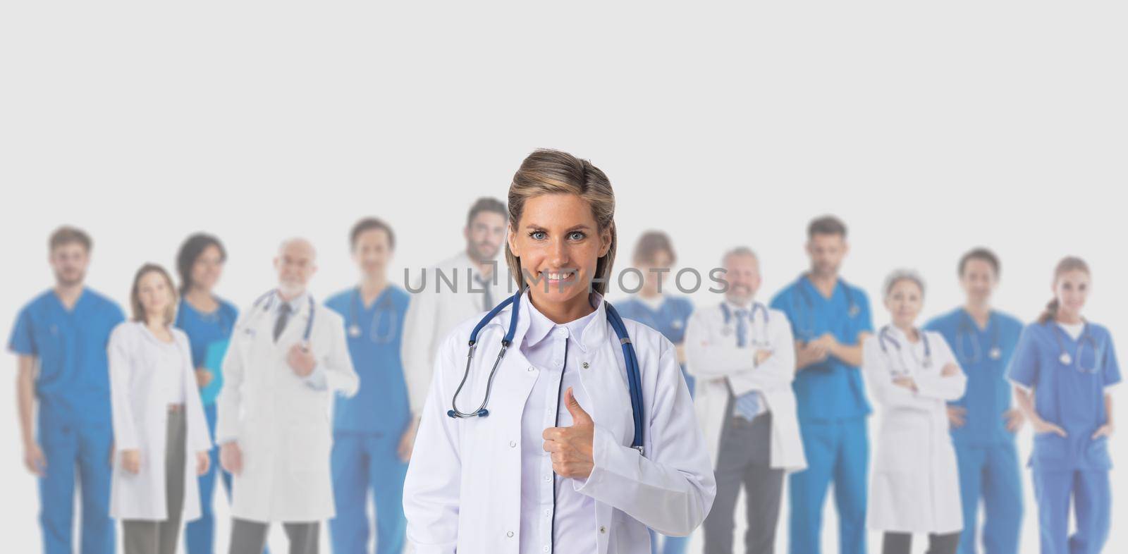 Female doctor giving thumbs up in front of a medical team